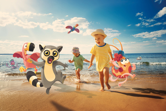 Kinder laufen mit dem Zeichentricktieren aus Kattas Welt am Strand entlang